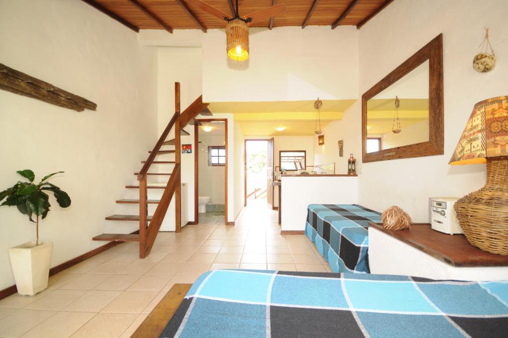 a living room with a bed and a staircase at Búzios Casa 3 in Búzios