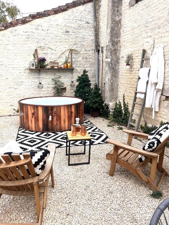 une terrasse avec un bain à remous, 2 chaises et une table dans l'établissement Greengates Rose Cottage Beautiful rural French home Hot tub Heated pool, à Chives