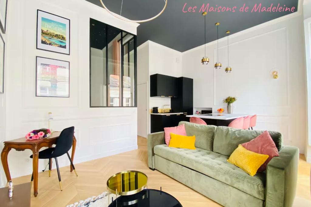 un salon avec un canapé vert et une table dans l'établissement L'Etoile du Sud - Les Maisons de Madeleine, à Nantes