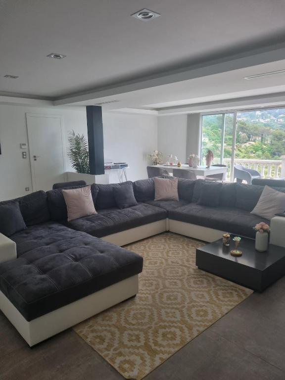 - un salon avec un grand canapé et une table dans l'établissement Magnifique appartement - St Martin de Peille, à Peille