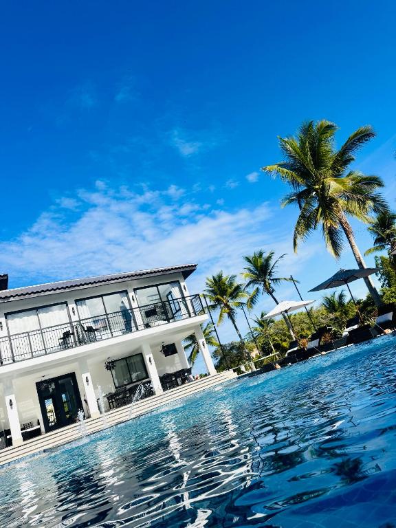 a resort with a swimming pool and palm trees at Fletcher American Manor Hotel & Resort in Prado
