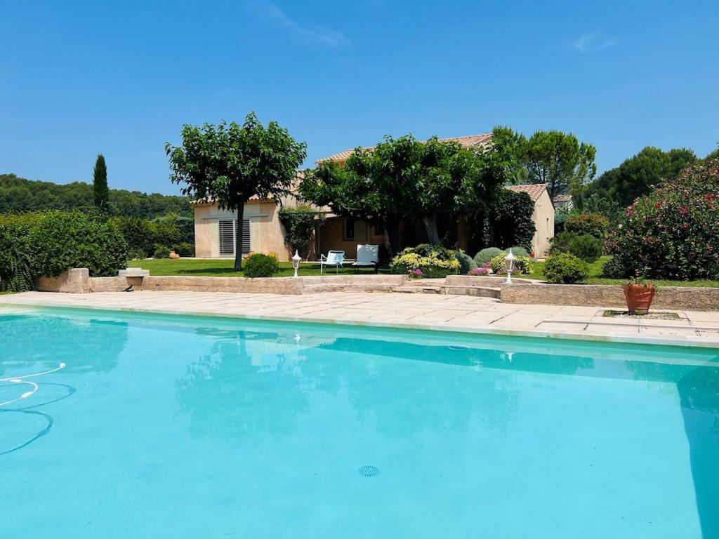 une grande piscine bleue devant une maison dans l'établissement Provencal Villa with Heated Pool near Lourmarin, à Lauris
