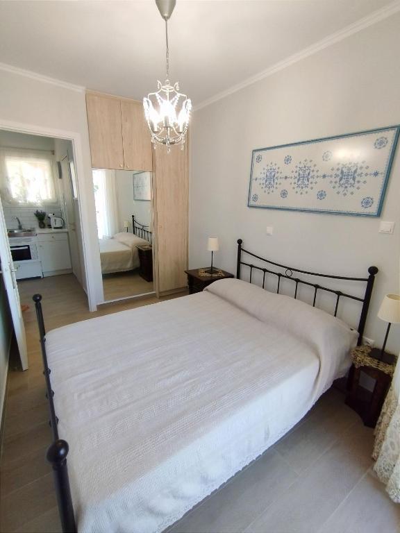 a bedroom with a bed and a chandelier at EAR - house Karia Lefkada in Kariá