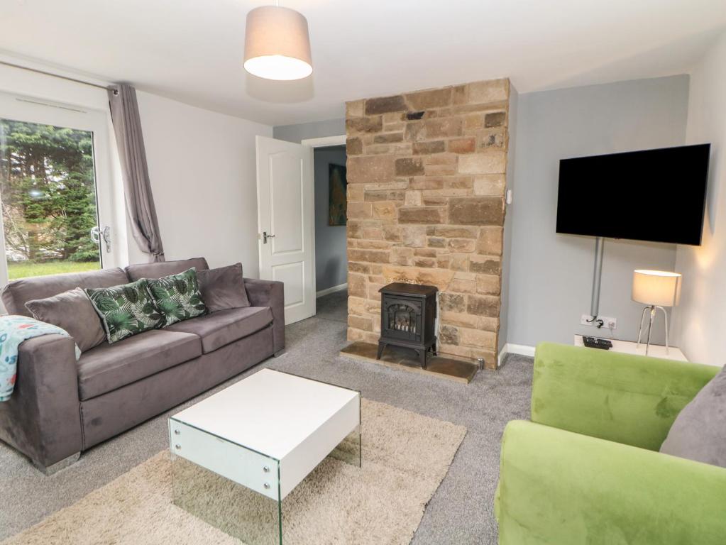 a living room with a couch and a fireplace at Cheshire House in Castleton