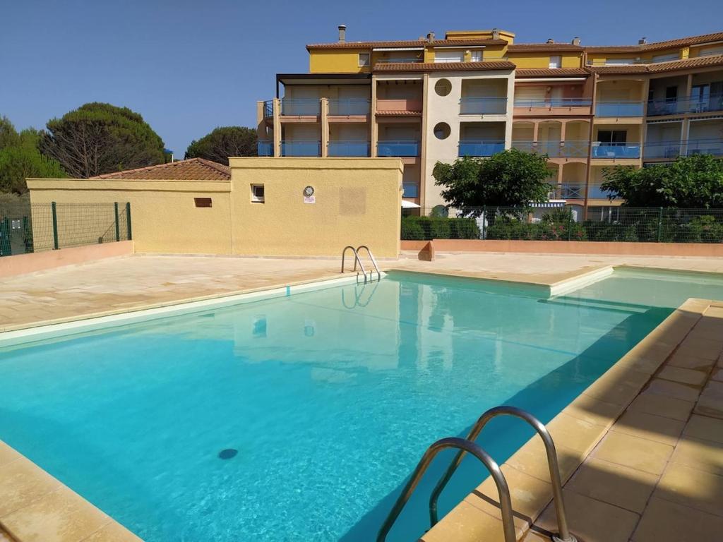 une grande piscine devant un immeuble dans l'établissement Appartement T4 avec terrasse et parking 50 m de la plage -V0744, à Vias