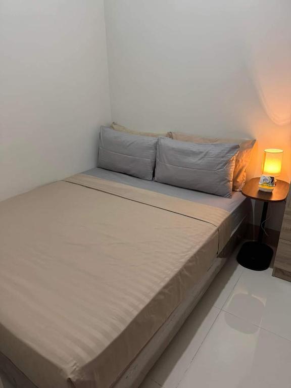 un lit dans une chambre avec une lampe sur une table dans l'établissement M S Staycation, à Manille