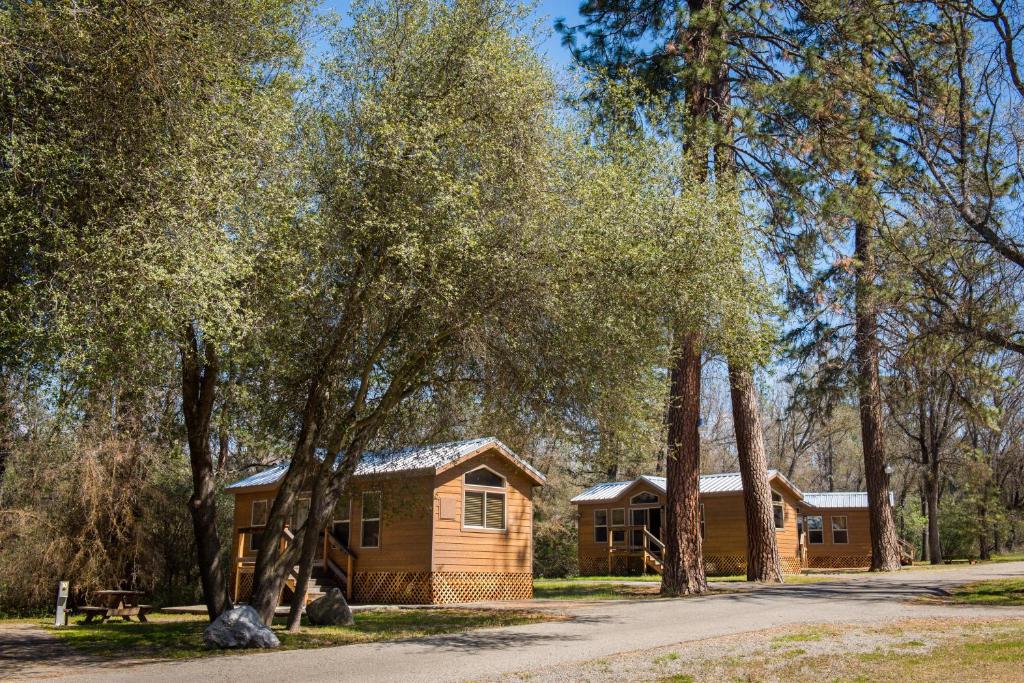 a log cabin with trees in front of it at Sierra Meadows in Ahwahnee
