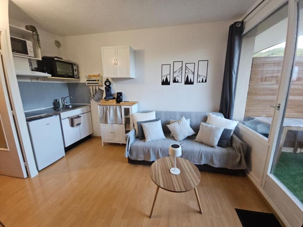 un salon avec un canapé et une table dans l'établissement Studio au pied des pistes refait à neuf, à Enchastrayes