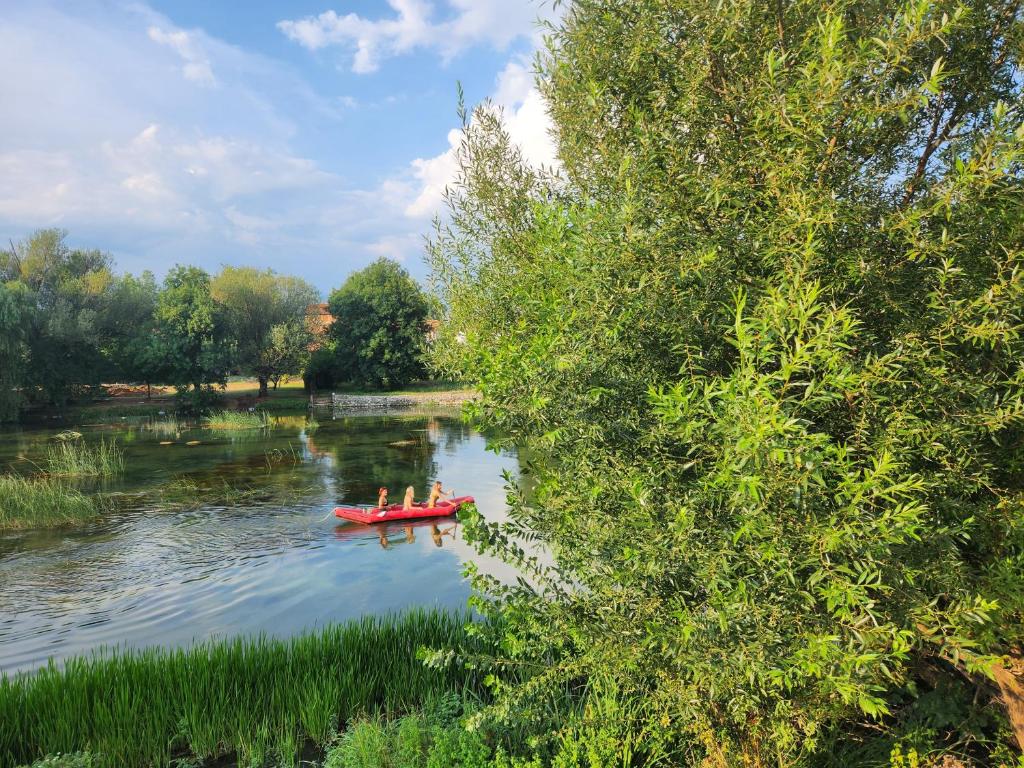 a group of people in a red boat on a river at Mostar - Luxury Villa Buna in Buna