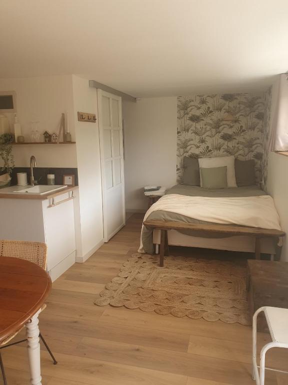 une petite chambre avec un lit et une cuisine dans l'établissement Studio SIMONE, à 2 pas de la plage, à Saint-Gilles-Croix-de-Vie