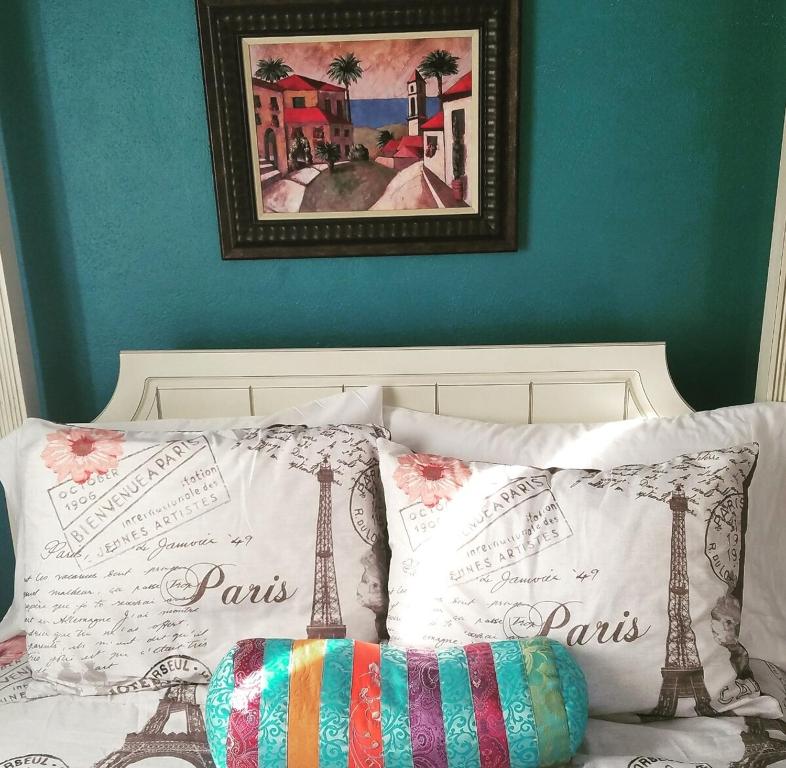 a bed with two pillows and a picture on the wall at The Zen Den in Del Norte