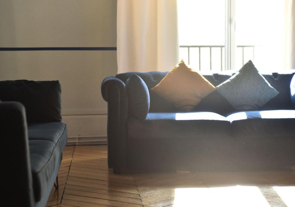 un canapé avec des coussins dessus dans un salon dans l'établissement Lovely flat in Latin quarter, à Paris
