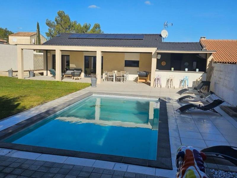 une piscine devant une maison dans l'établissement Villa Levant Piscine et Calme, à Poulx