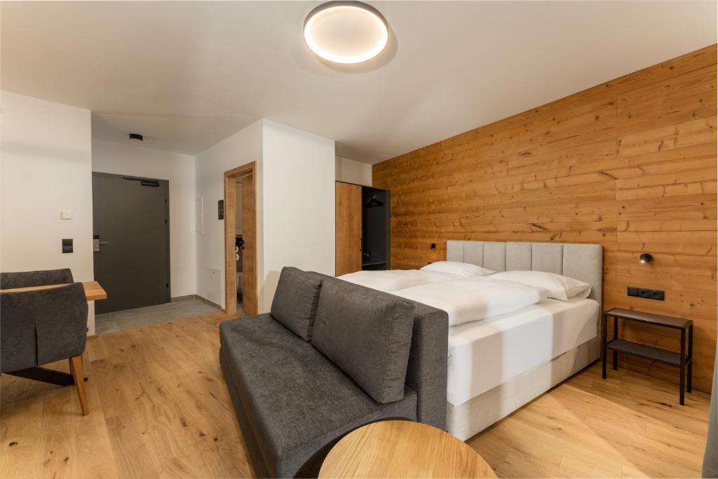 a bedroom with a large white bed and a chair at Pure Alpine Suites in Schladming