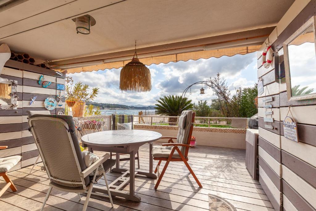 un patio con tavolo e sedie su un balcone di Les pieds dans l'eau a Virebelle