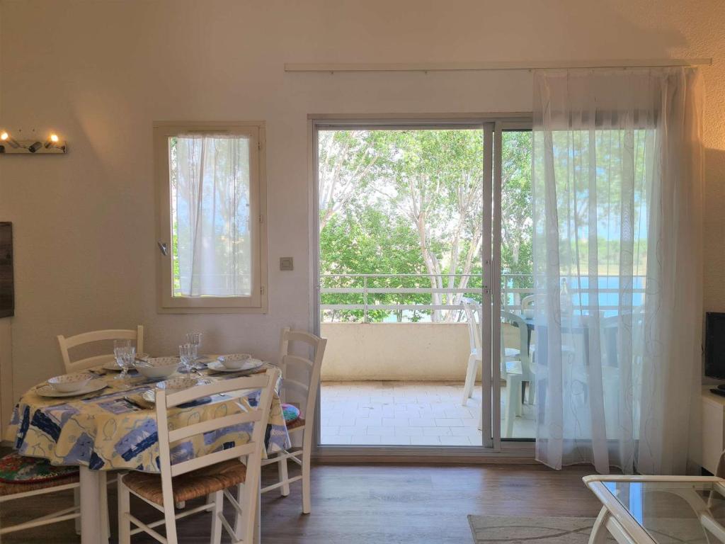 d'une salle à manger avec une table et une porte coulissante en verre. dans l'établissement Appt Studio - cabine -mezzanine - CAP D'AGDE CT580-432, au Cap d'Agde