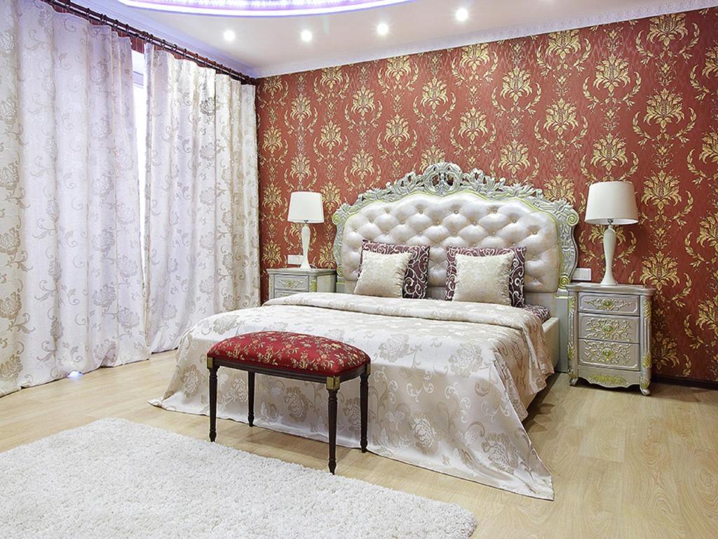 una camera da letto con un letto grande con una parete rossa di PaulMarie Apartments on Mayakovskogo a Brest