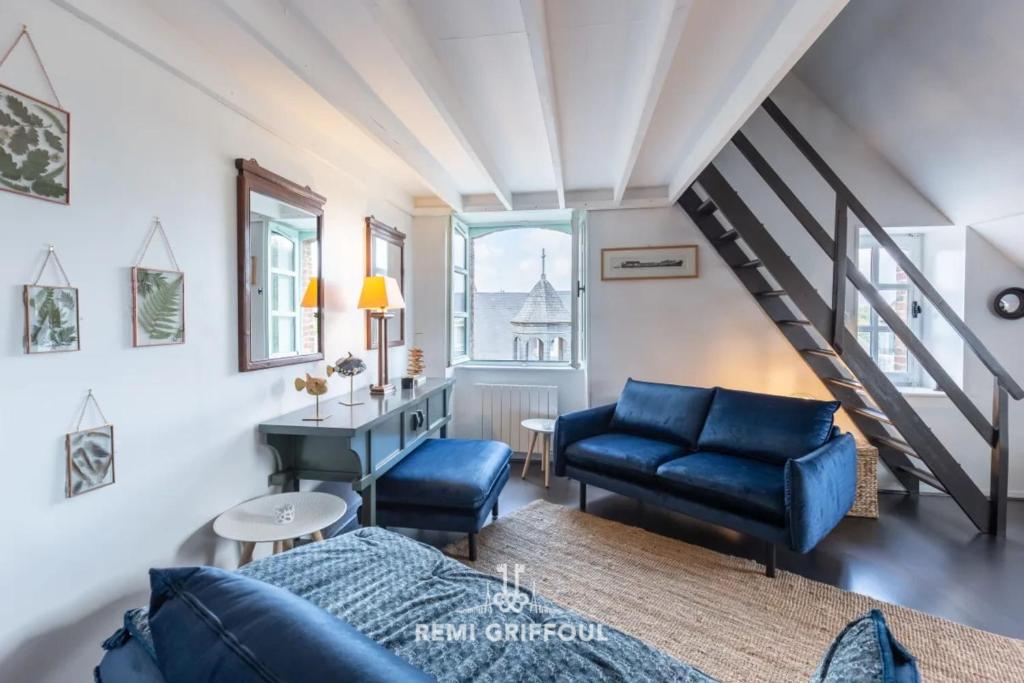 Il comprend un salon doté d'un mobilier bleu et d'un escalier. dans l'établissement Le Phare Bleu Center & Beach 2 to 4 guests, à Honfleur