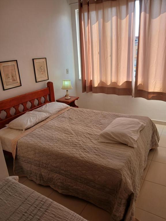 a bedroom with two beds and a window at Apartamento in Cabo Frio