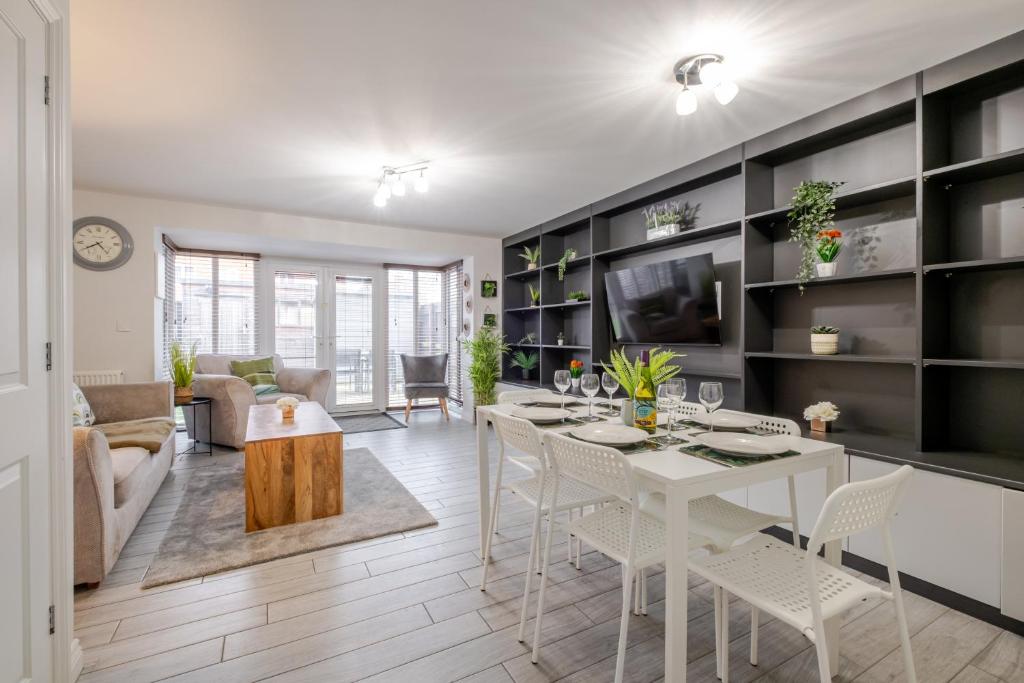 a living room with a white table and chairs at Comfy & stylish 4 bed house in Bedford
