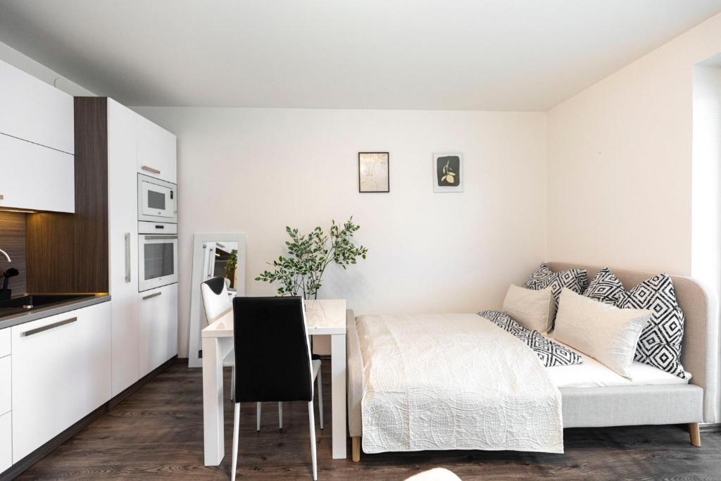 ALURE RESIDENCES 14 & 24h self check-in, private parking in front of the apartment building included, new building, CITY CENTER في بانسكا بيستريتسا: غرفه بطاوله وسرير ومطبخ