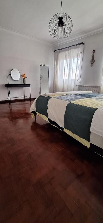 a bedroom with a bed and a table and a window at Casa José & Maria, casa espaçosa para famílias e grupos até 10 pessoas in Braga
