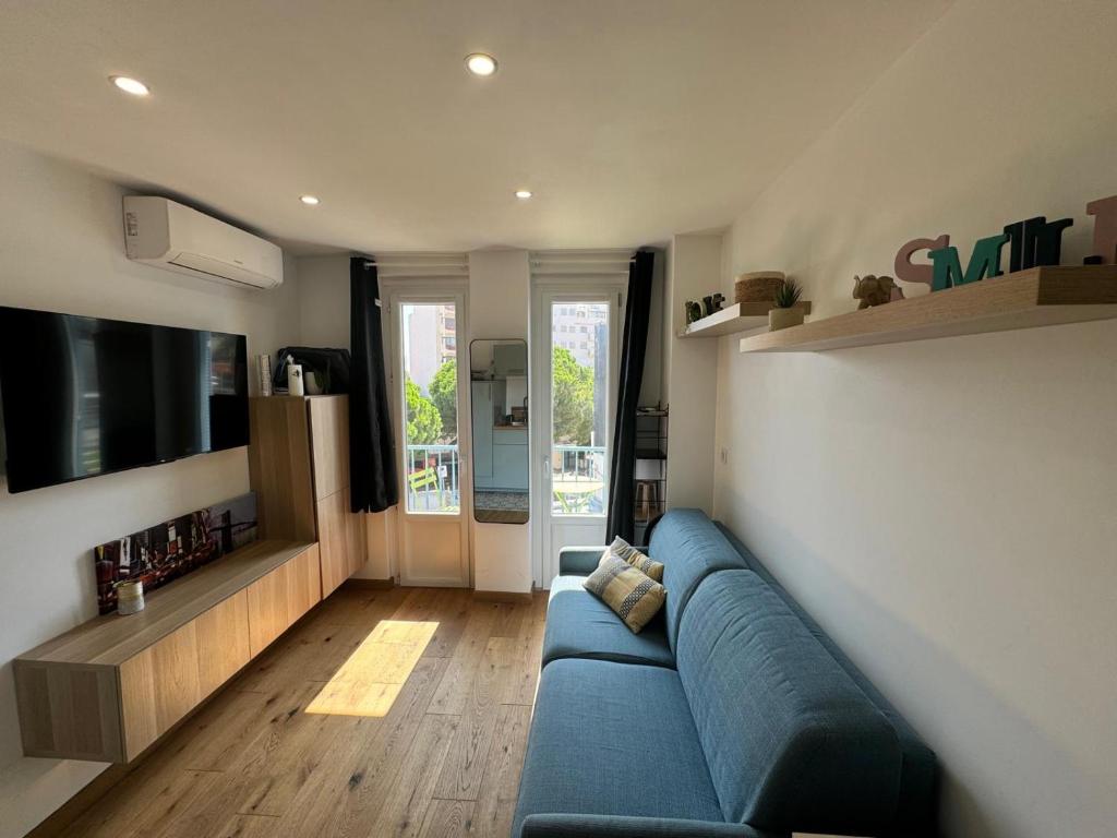 un salon avec un canapé bleu et une télévision dans l'établissement Résidence des Îles - Apt 2 Pers ultra Centre, à Antibes