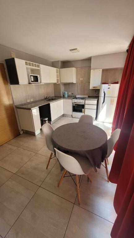 萨尔塔Dean Funes SUITES 108的房间里有一张桌子和几把椅子的厨房