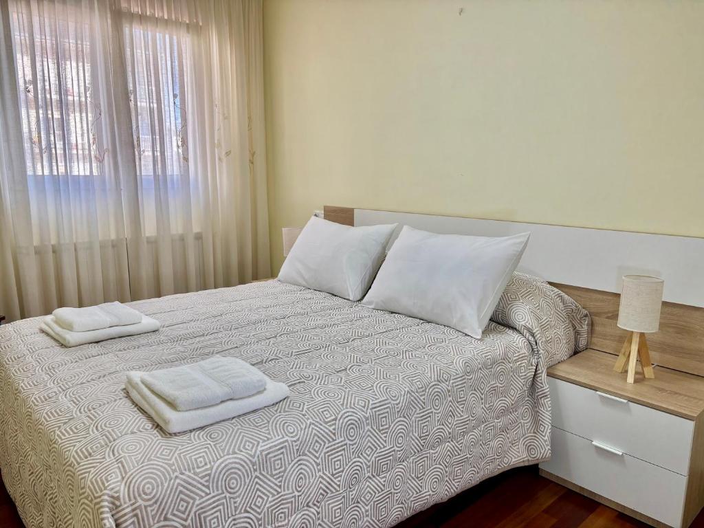 a bedroom with a bed with two towels on it at Apartamento Ribeira Sacra in Monforte de Lemos