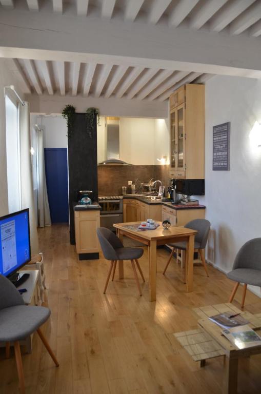 une cuisine avec une table et des chaises dans une pièce dans l'établissement Appartement atypique dans un ancien couvent, à LʼIsle-sur-la-Sorgue