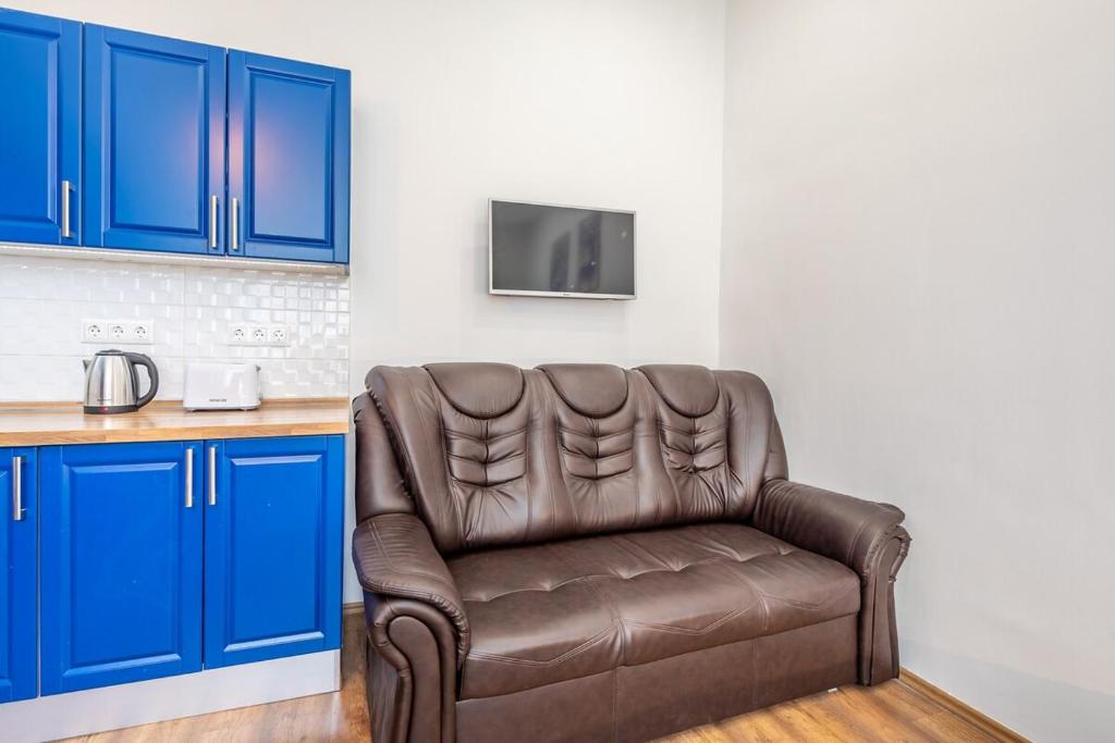 a brown leather couch in a kitchen with blue cabinets at Star House in the city in Budapest