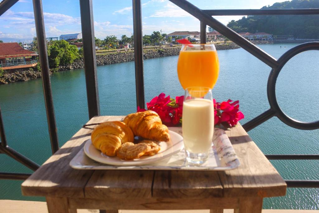 a table with a plate of pastries and a glass of orange juice at The Beach House in Panama City