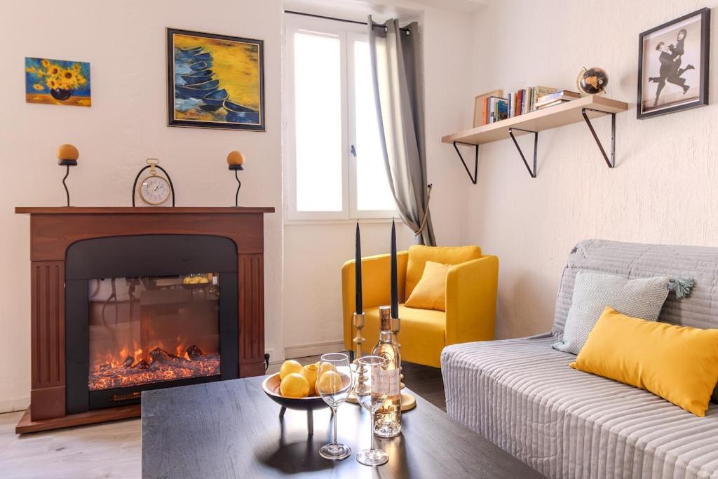 un salon avec une cheminée et un canapé dans l'établissement Apparemment charmant au cœur du Suquet, à Cannes