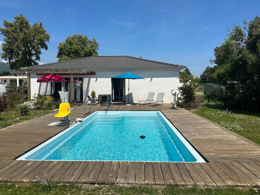 une piscine avec une table, des chaises et un parasol dans l'établissement Villa avec piscine privée Santa Maria Poggio, à Santa-Maria-Poggio