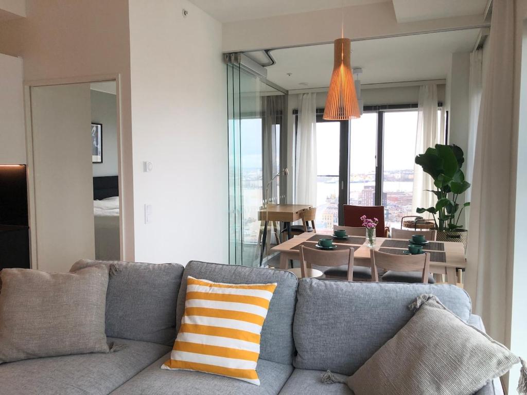 un salon avec un canapé et une salle à manger dans l'établissement Spacious corner apartment with sea view, à Helsinki