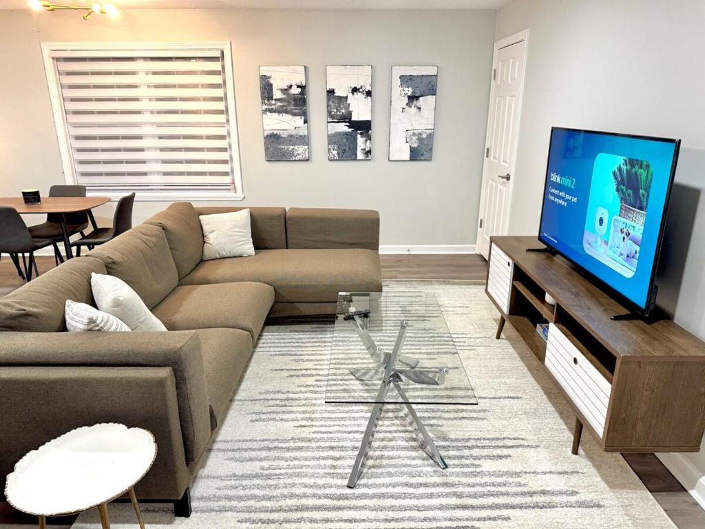 a living room with a couch and a flat screen tv at Superb Luxurious 3Br in the Heart of Providence in Providence