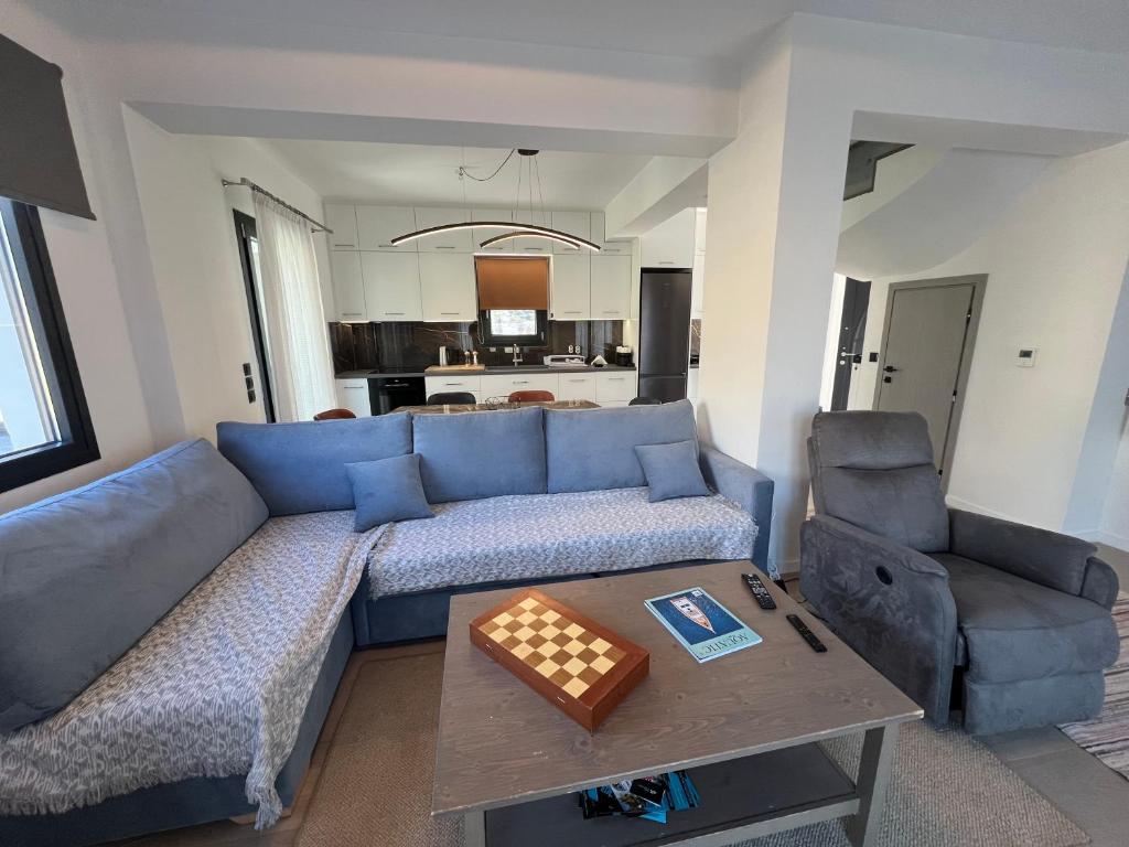 a living room with a blue couch and a table at Arachova Villa Paris in Kalívia