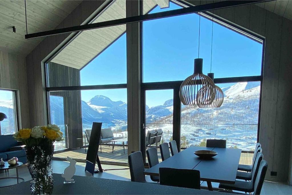 una sala da pranzo con un tavolo e una grande finestra di The Panoramic Chalet a Stranda