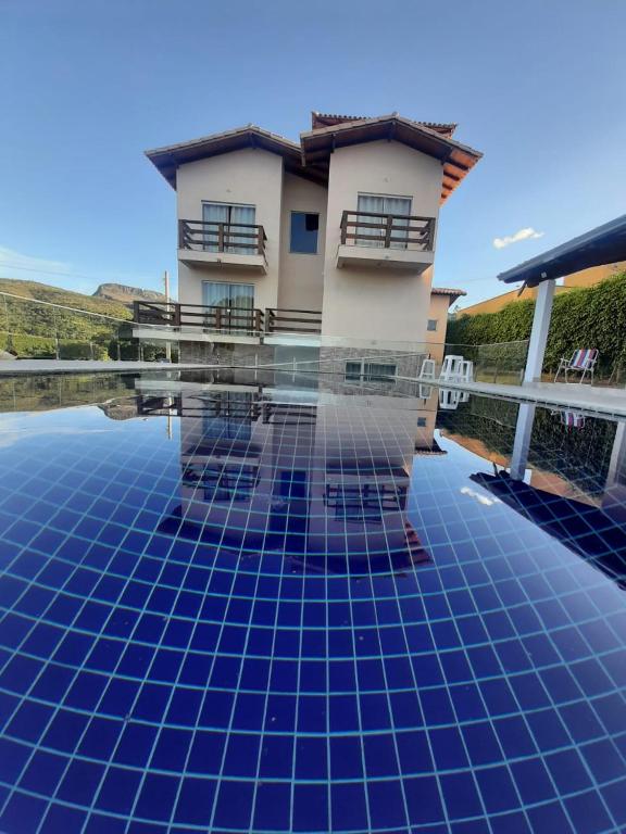 a villa with a swimming pool in front of a house at Casa em Capitolio-MG in Capitólio