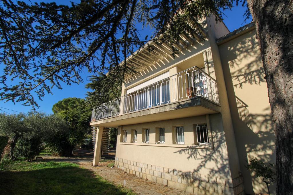 un bâtiment avec un balcon sur le côté dans l'établissement Clos Garrigue, à Poulx