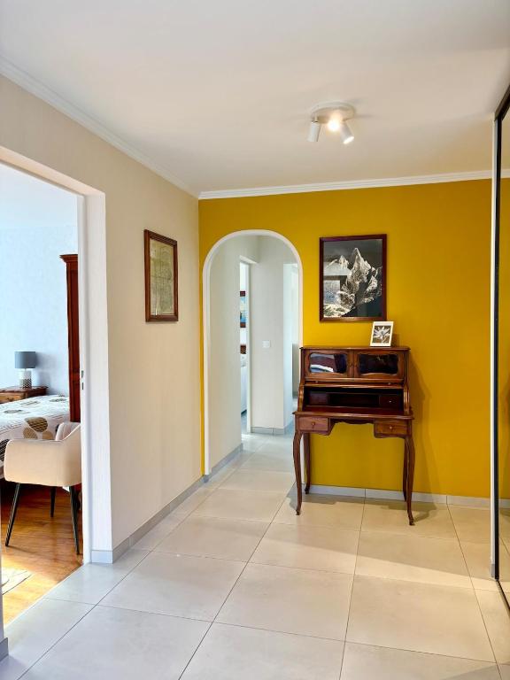 Elle comprend un salon avec des murs jaunes et un bureau. dans l'établissement Lovely apartment in Albertville, à Albertville