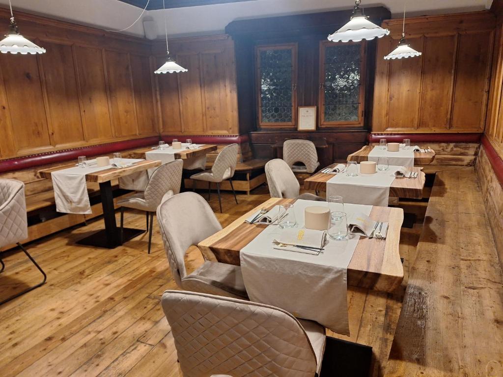 een restaurant met houten wanden en tafels en stoelen bij Santer Klause in Merano