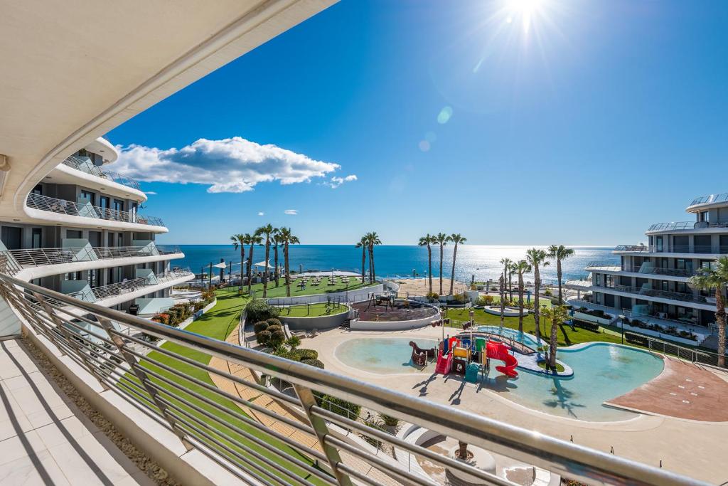 a view of the beach from the balcony of a resort at Luxury Seaview Beachfront Apartment Pools,Jacuzzi,Gym in Arenales del Sol