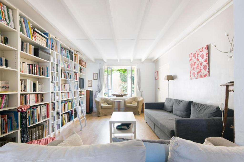 un salon rempli de nombreux livres dans l'établissement Grande Maison de famille patio, babyfoot, vélos, wifi, à Marennes
