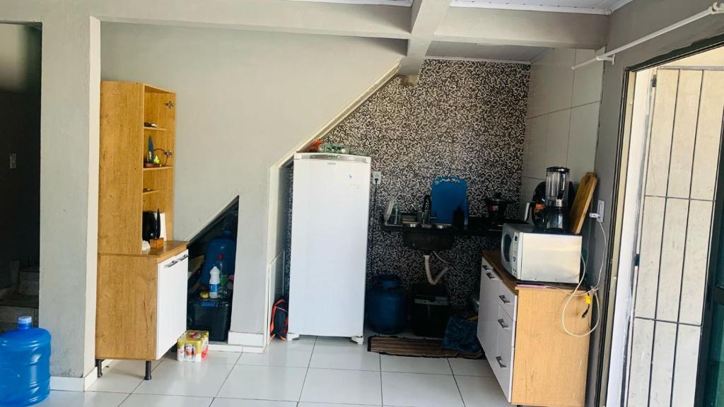 a kitchen with a refrigerator in a room at casa de praia em carne de vaca Pe in Carne de Vaca