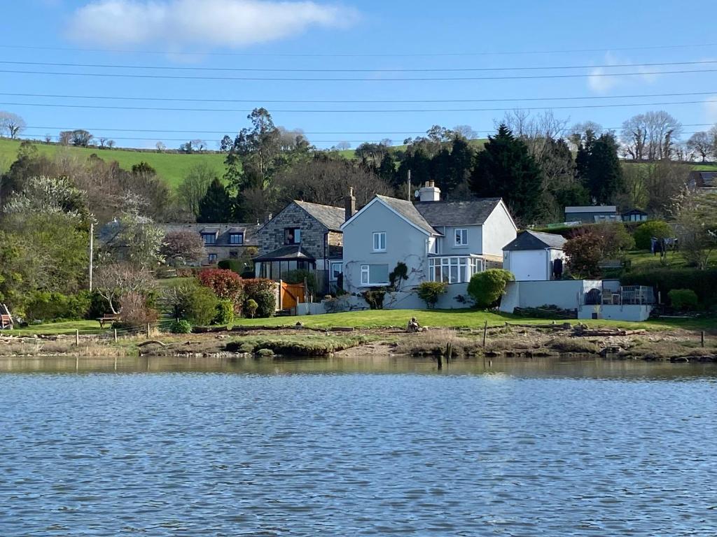 a house on the shore of a body of water at Clamoak Cottage in Yelverton