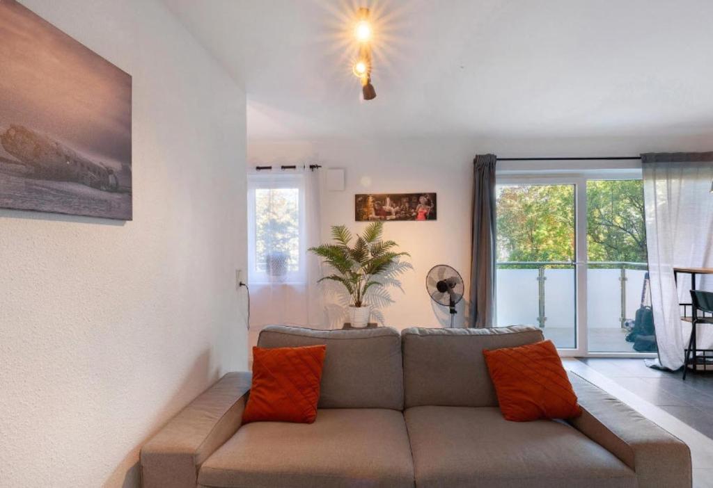 a living room with a couch with orange pillows at Apartment Zola in Frankenthal