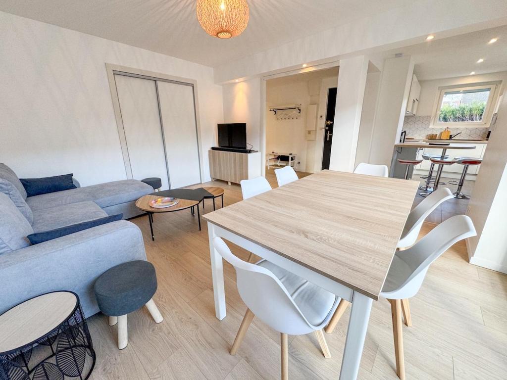 un salon avec une table et un canapé bleu dans l'établissement Cocon idylique, Clim, Lac et Montagnes, Jardin, à Saint-Jorioz