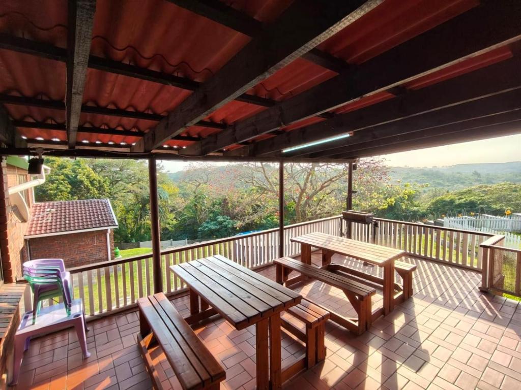 a deck with a picnic table and chairs on a balcony at Sole Sands Bliss Guesthouse in Meer en See