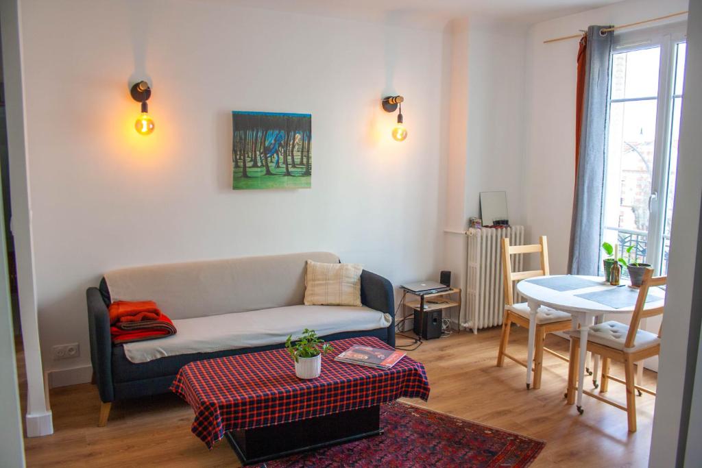 un salon avec un canapé et une table dans l'établissement Charming 45m2 apartment, à Vincennes